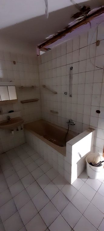 Alte Badewanne mit kleinformatigen weißen Fliesen