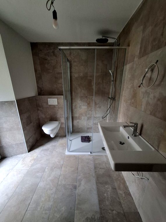 Neues Bad mit Regendusche, Waschtisch und Natursteinoptik
