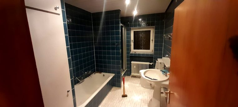 Altes Bad mit blauen Fliesen und Badewanne vor der Sanierung in Birkenfeld