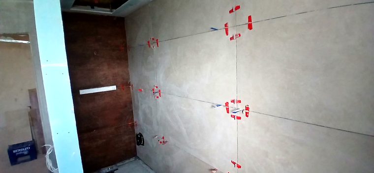 Großformatige Wandfliesen mit Nivelliersystem neben der Wand in Rostoptik