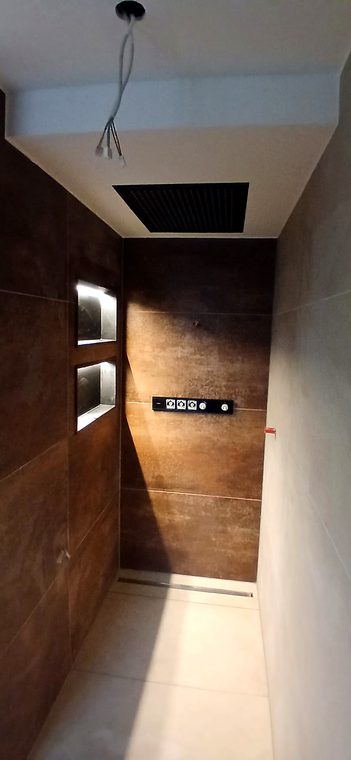 Bodengleiche Dusche mit beleuchteten Wandnischen und Regenbrause