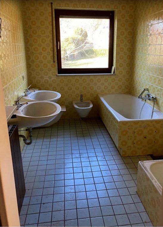 Bad mit gelben Dekorfliesen, zwei Waschbecken und Wanne vor dem Umbau in Hermeskeil