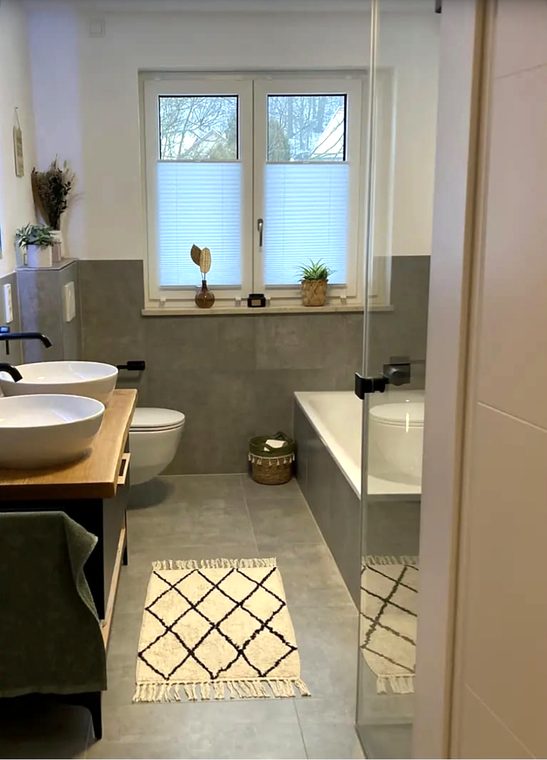 Neues Bad mit Doppelwaschtisch, Wand-WC und Wanne in Grau und Weiß