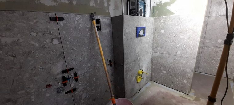 Bad mit großformatigen Fliesen in Terrazzo-Optik während der Verlegung