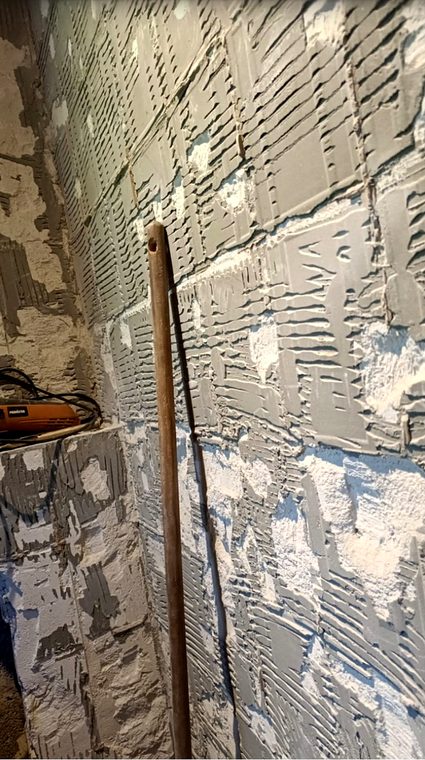 Vorbereitete Wand mit alten Kleberesten vor dem Neuaufbau
