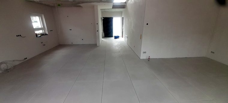 Langer Wohnbereich mit hellen Großformatfliesen