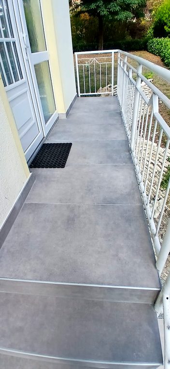 Balkon mit neuem großformatigem Fliesenbelag in Grau